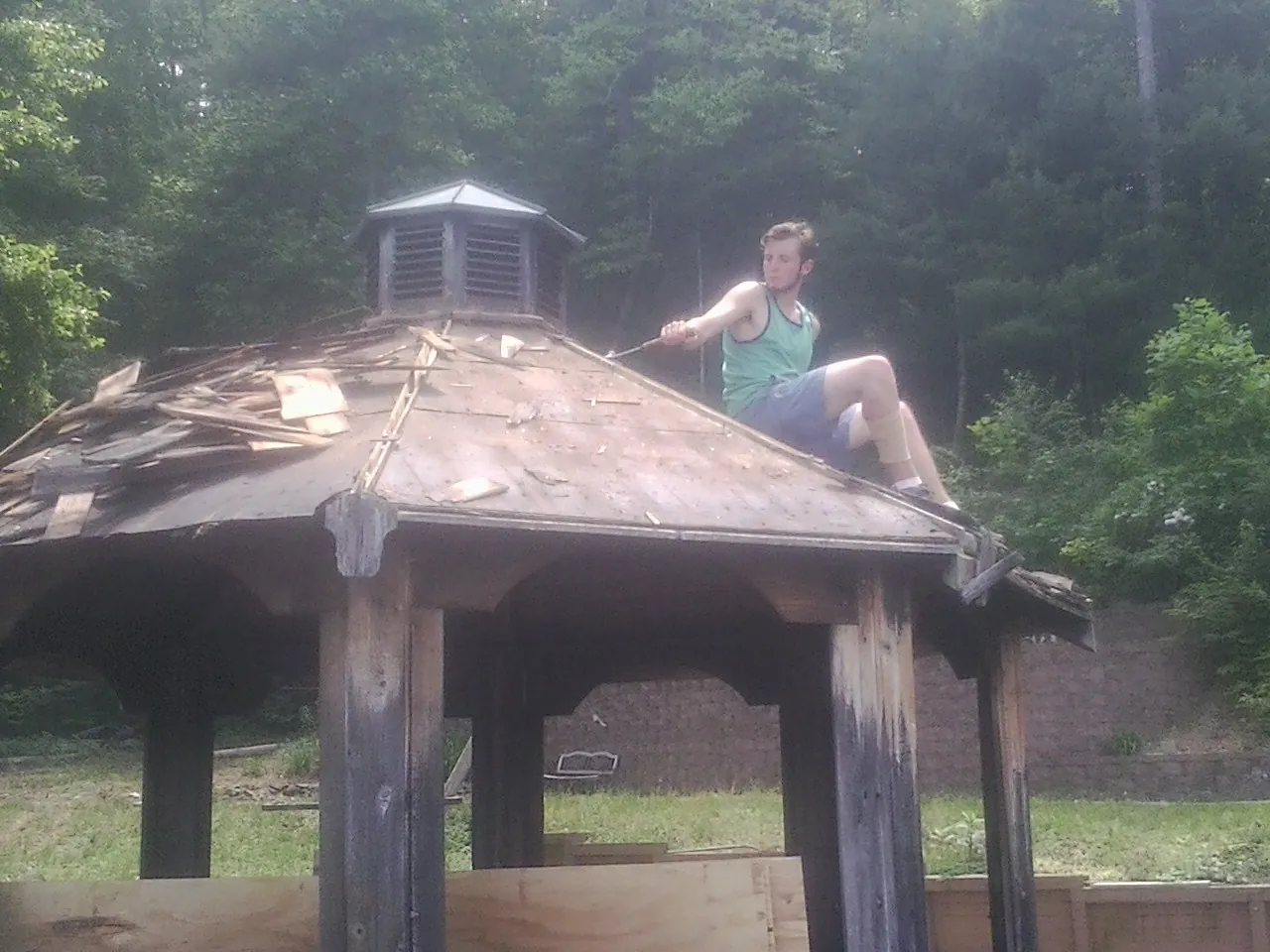 Tearing the old roof off a wooden gazebo before new shakes in Paris
