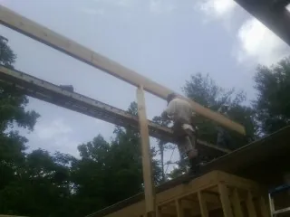 Carpenter setting a ridge beam over a new addition frame — Ice Dam Removal by Roofing Brothers in Paris